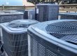 Climatizadores industriales - Técnico de HVAC latino que hace el papeleo mientras trabaja en el mantenimiento de los sistemas HVAC.
