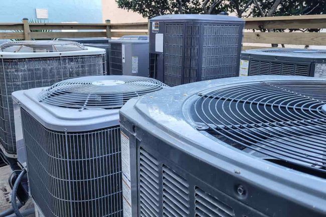 climatizadores-industriales Climatizadores industriales - Técnico de HVAC latino que hace el papeleo mientras trabaja en el mantenimiento de los sistemas HVAC.