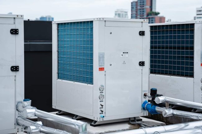 Tipos de chiller – Compresor de aire acondicionado instalado en el techo de un edificio, junto con aire acondicionado. Tipos de chiller - Compresor de aire acondicionado instalado en el techo de un edificio, junto con aire acondicionado.